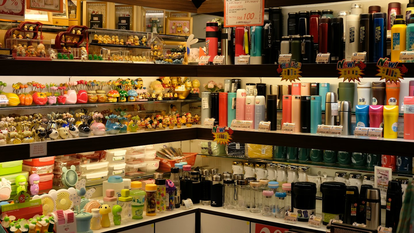 Retail store shelves stocked with kitchenware and colorful drink bottles.